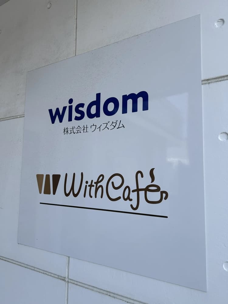 株式会社ウィズダム(wisdom)と With Café の看板